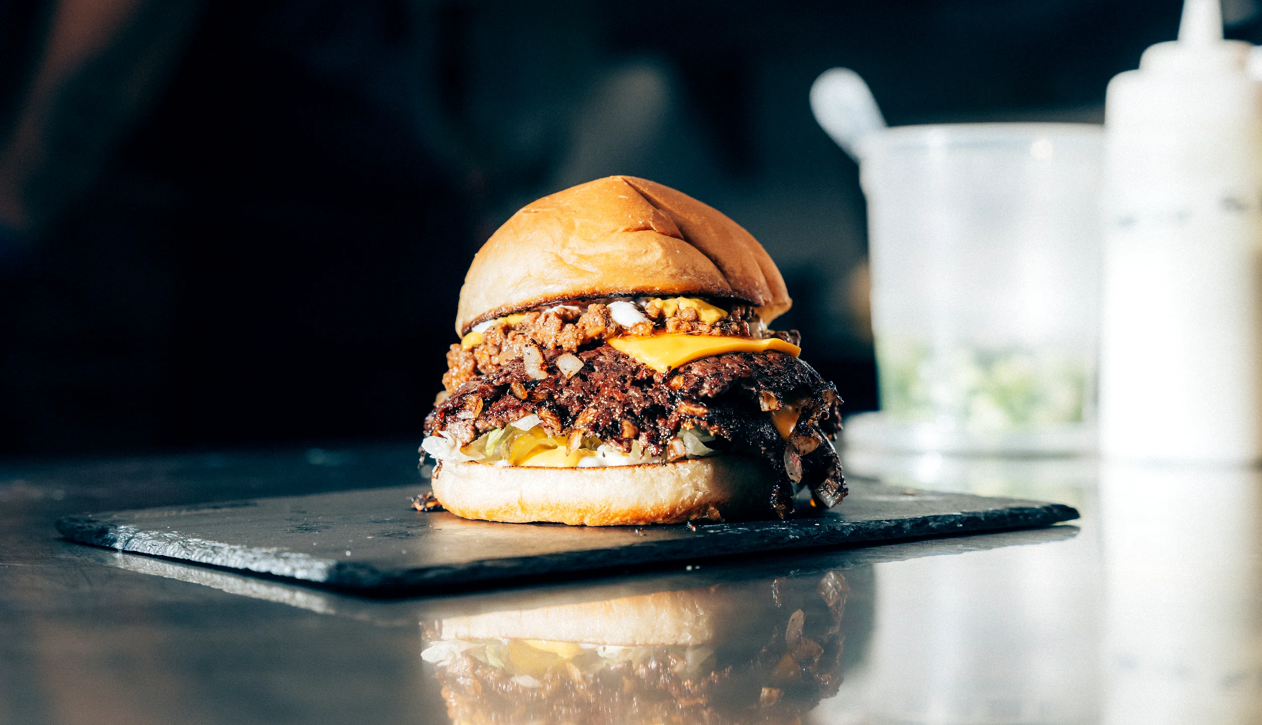 Double smash burger with caramelized onions on a slate board