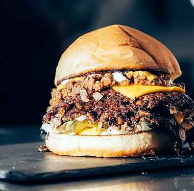 Double smash burger with caramelized onions on a slate board