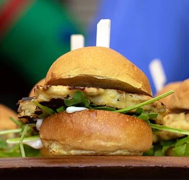 Sliders with arugula on a wooden board