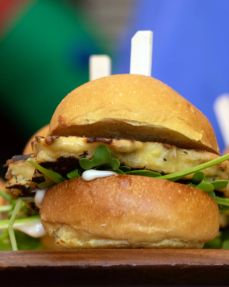 Tray of sliders with arugula served at a catered event