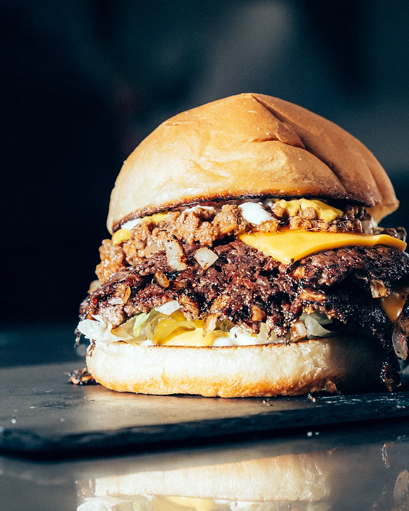 Double smash burger with caramelized onions on a slate board