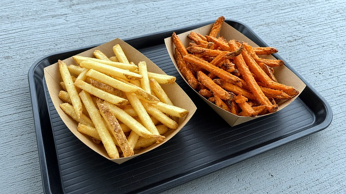 Fries and yam fries in paper boats on a tray