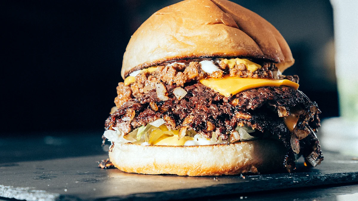 Double smash burger with caramelized onions on a slate board